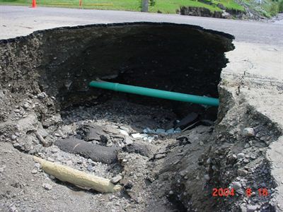 Road damage exposing pipeline