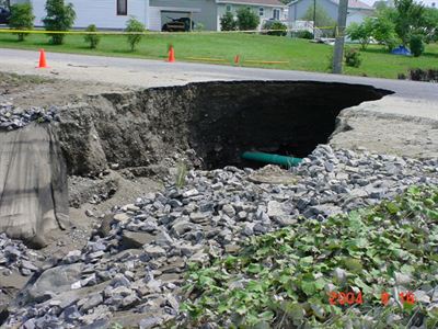 Road damage exposing pipeline