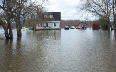 Maison blanche inondée et quatre voitures submergées